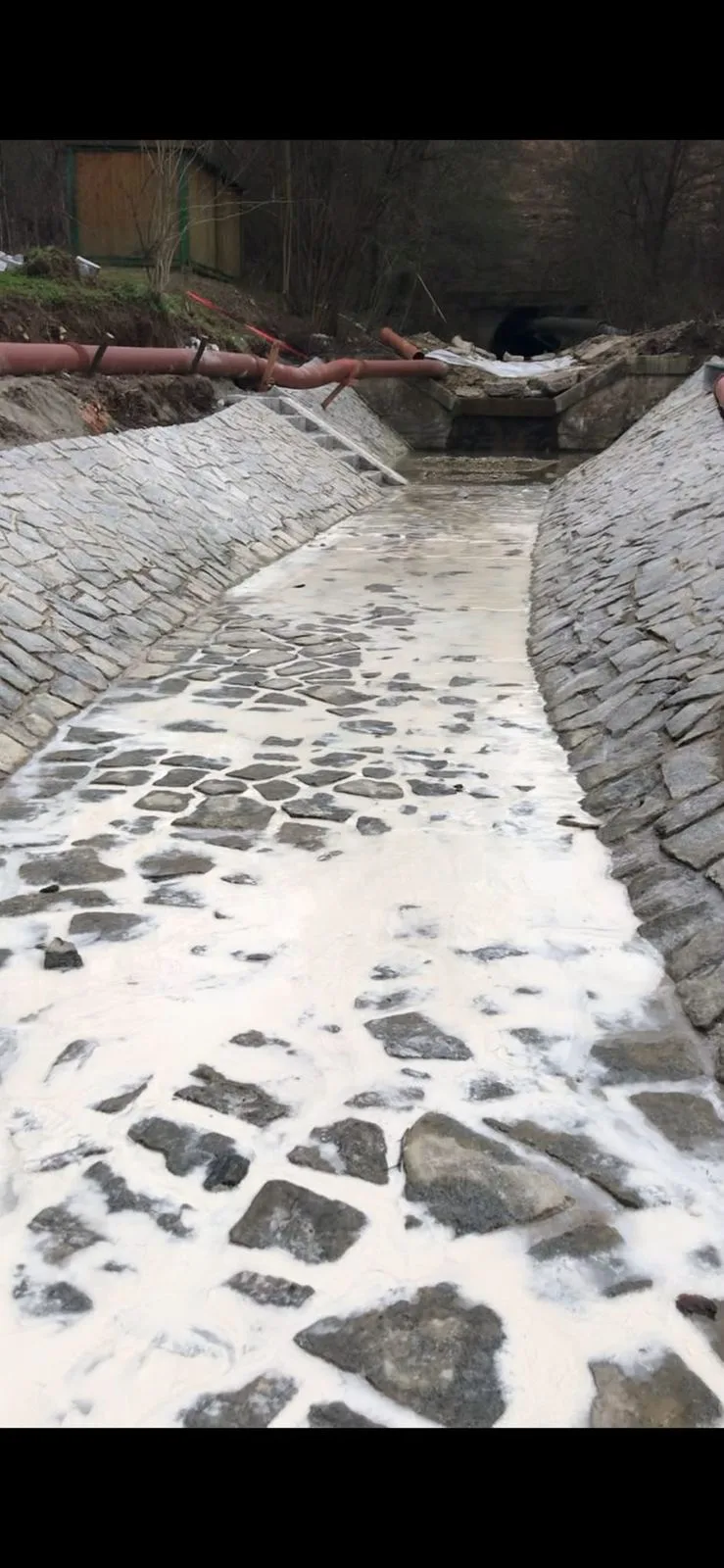 Dlážděné koryto potoka a kamenná nádrž